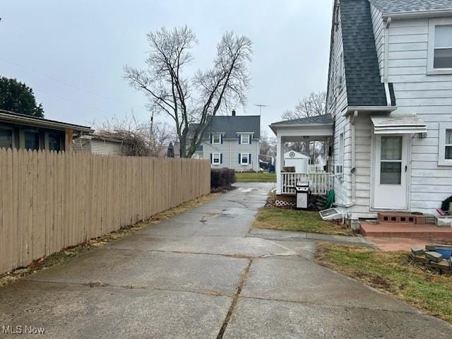 exterior space with entry steps, roof with shingles, and fence