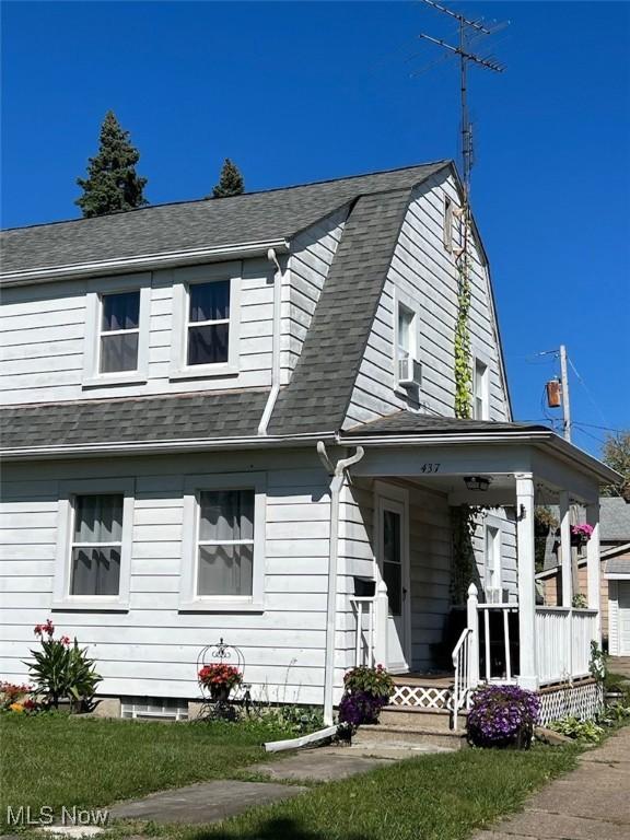 dutch colonial with cooling unit, covered porch, roof with shingles, and a gambrel roof