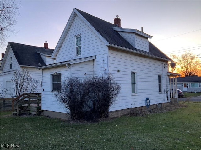 back house at dusk with a yard