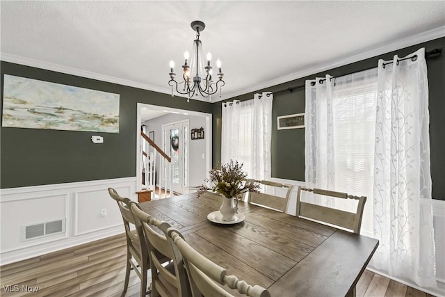 dining room featuring a notable chandelier, crown molding, and wood-type flooring