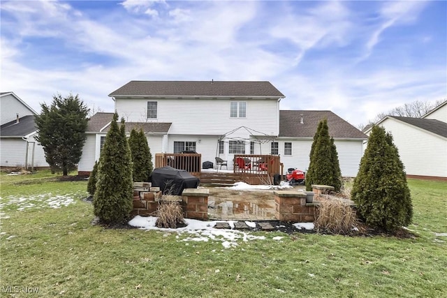 rear view of property with a wooden deck and a lawn