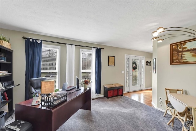 carpeted office with a chandelier and a textured ceiling