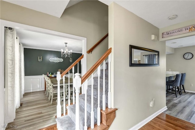 stairway featuring hardwood / wood-style flooring and a notable chandelier