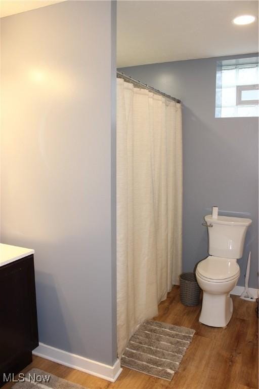 bathroom with vanity, toilet, and hardwood / wood-style floors