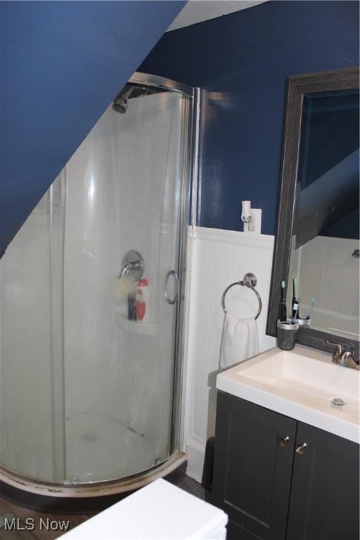 bathroom featuring tile walls, vanity, and walk in shower