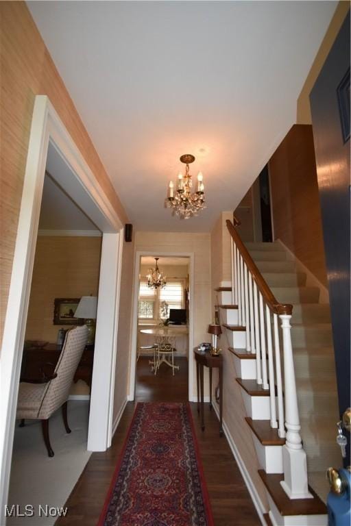 corridor with a notable chandelier and dark hardwood / wood-style floors