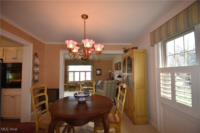 dining space featuring ornamental molding and a chandelier