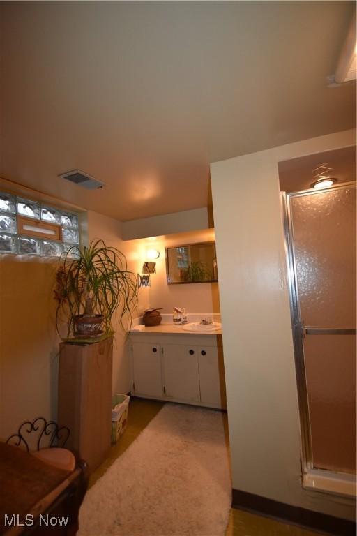 bathroom with vanity and a shower with shower door