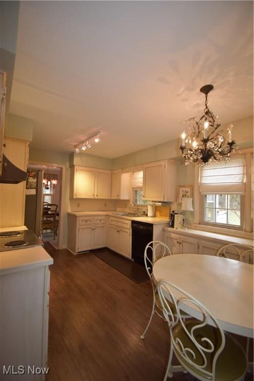 kitchen with white cabinetry, dark hardwood / wood-style floors, dishwasher, a notable chandelier, and pendant lighting