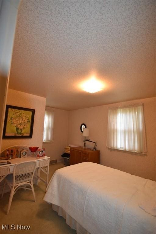 carpeted bedroom with a textured ceiling