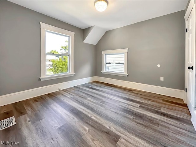 bonus room with vaulted ceiling, a healthy amount of sunlight, and hardwood / wood-style floors