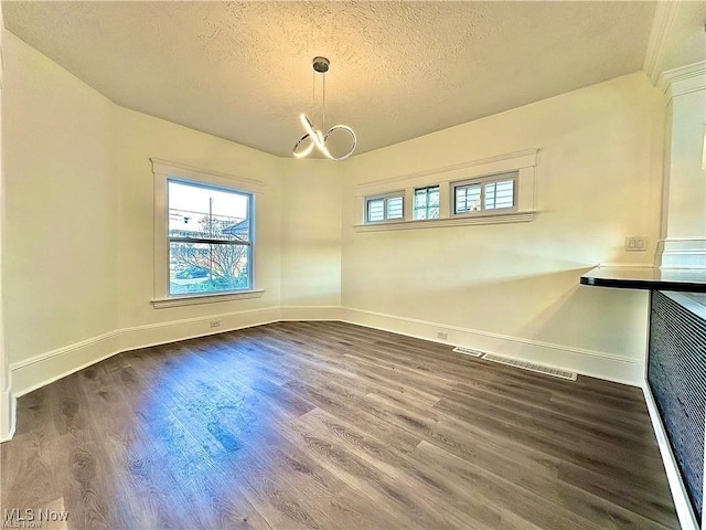 unfurnished dining area featuring hardwood / wood-style floors and a textured ceiling