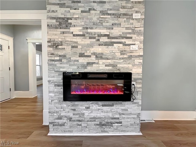 details featuring a stone fireplace and hardwood / wood-style floors