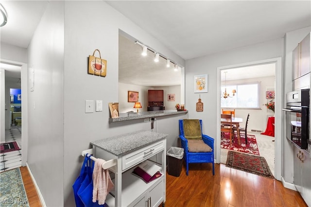 interior space with hardwood / wood-style flooring, track lighting, and a notable chandelier