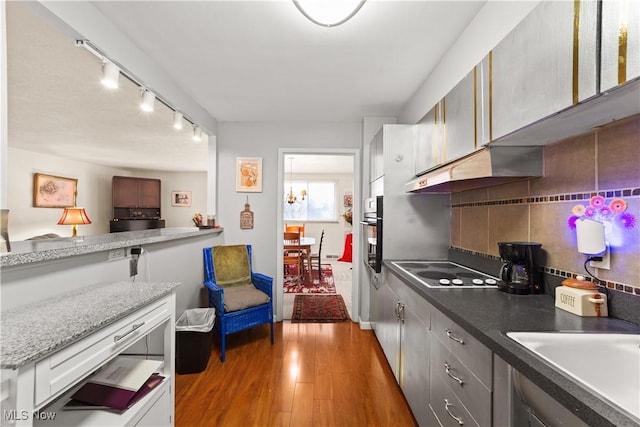 kitchen with white cabinetry, electric stovetop, sink, backsplash, and dark hardwood / wood-style flooring