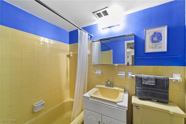 full bathroom with vanity, tile walls, shower / bath combination with curtain, and toilet