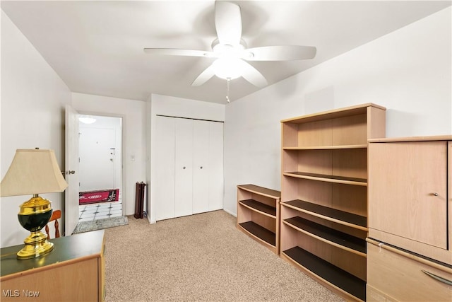 carpeted bedroom with ceiling fan and a closet