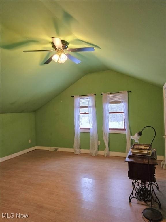 additional living space with visible vents, wood finished floors, a ceiling fan, and vaulted ceiling