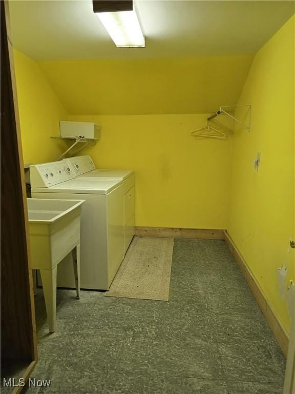 washroom with laundry area, washing machine and dryer, and baseboards