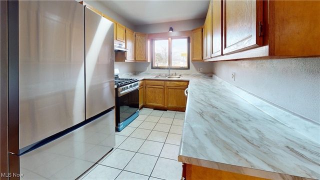 kitchen featuring stainless steel appliances, light tile patterned flooring, and sink