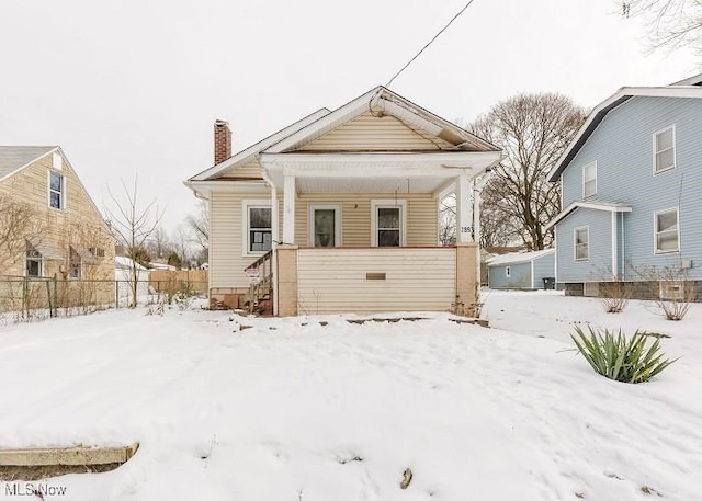 view of snow covered back of property