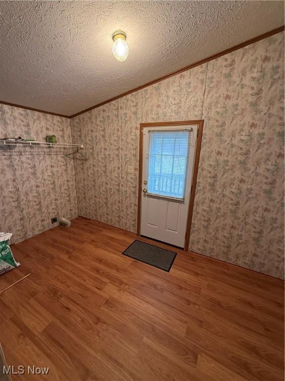 entrance foyer featuring hardwood / wood-style floors, crown molding, and a textured ceiling