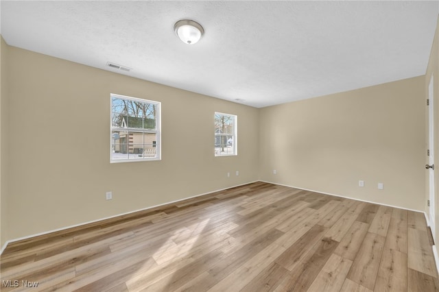 empty room featuring light hardwood / wood-style flooring and a textured ceiling