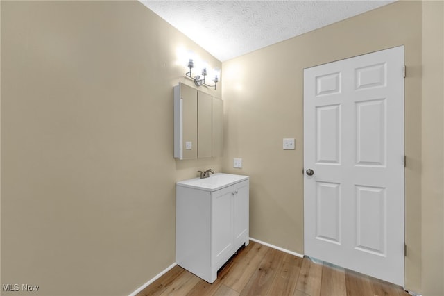 bathroom with vanity, wood-type flooring, and a textured ceiling