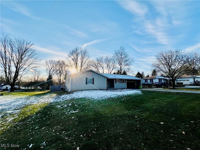 view of side of property with a garage and a lawn