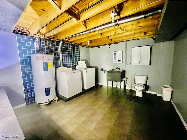 basement featuring electric water heater, sink, and independent washer and dryer