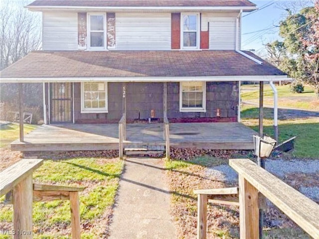 rear view of house with a yard and covered porch