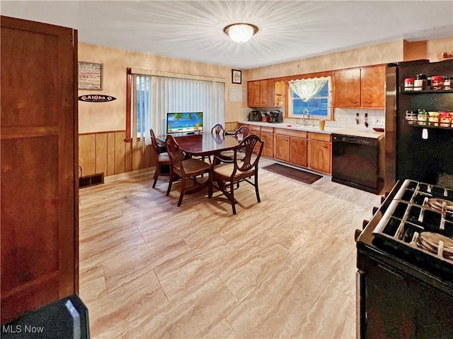 kitchen with stainless steel refrigerator, black dishwasher, sink, and range with gas cooktop