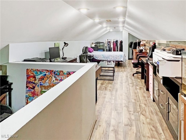 bedroom with lofted ceiling and light hardwood / wood-style floors