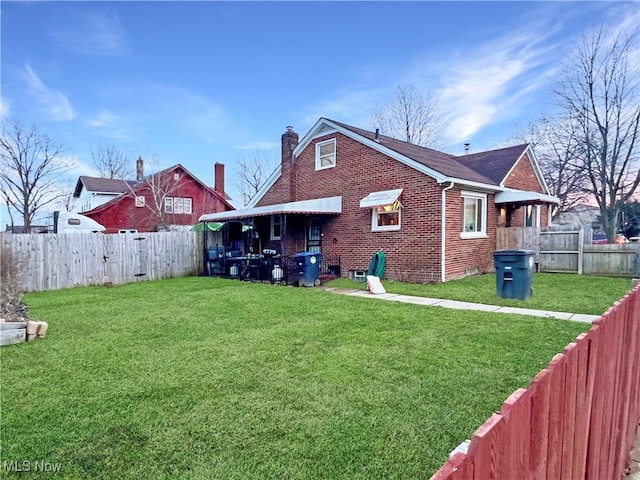 rear view of property with a yard