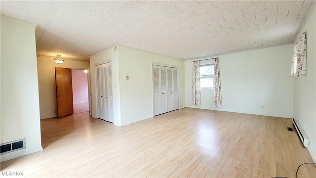 unfurnished room featuring a textured ceiling and light hardwood / wood-style flooring