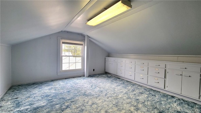 additional living space featuring lofted ceiling and light colored carpet