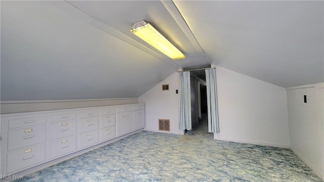 bonus room with vaulted ceiling and light carpet