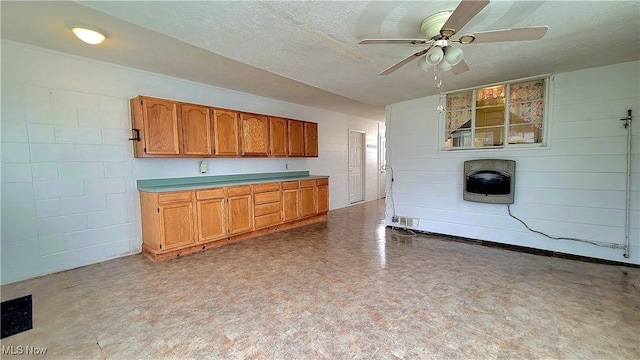 kitchen with heating unit, ceiling fan, and a textured ceiling