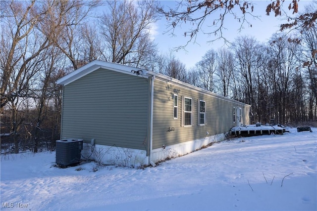 view of snowy exterior featuring central AC