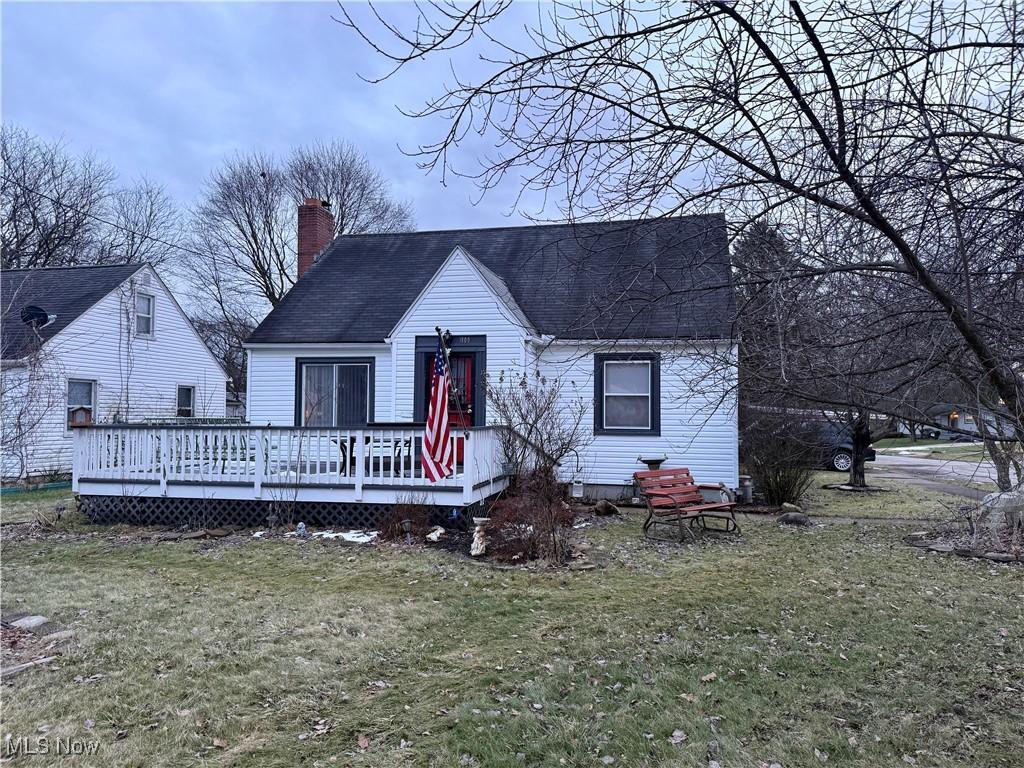 bungalow featuring a deck and a front lawn