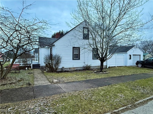 view of side of property with a garage and a lawn