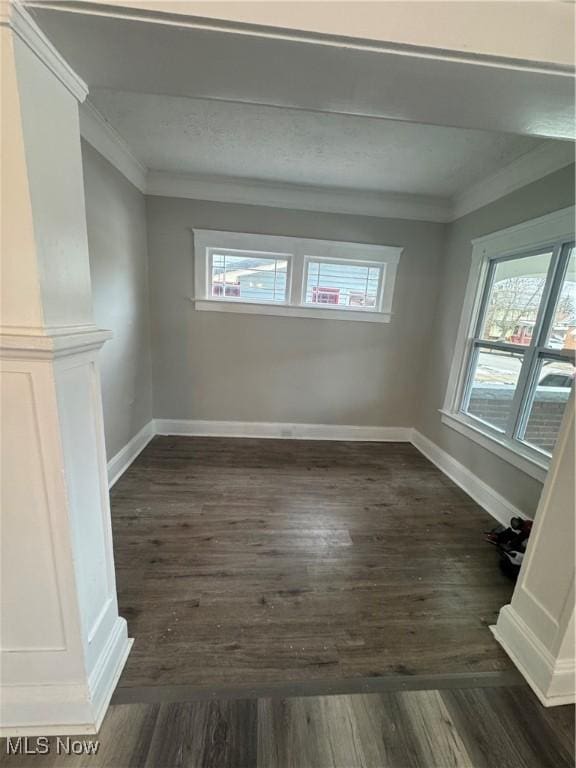 unfurnished dining area with dark wood-type flooring and ornamental molding