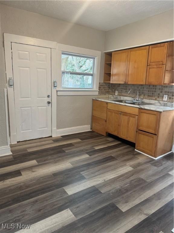 kitchen with tasteful backsplash, sink, dark wood-type flooring, and a textured ceiling