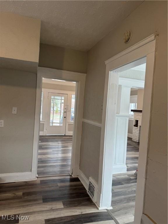 hall featuring a textured ceiling and dark hardwood / wood-style flooring