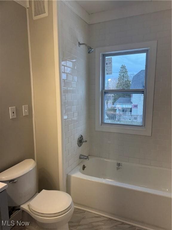 full bathroom featuring tiled shower / bath, vanity, and toilet