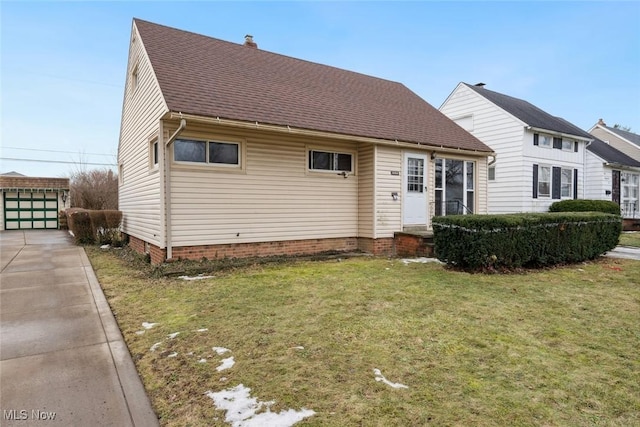 view of front of house featuring a garage, an outdoor structure, and a front yard