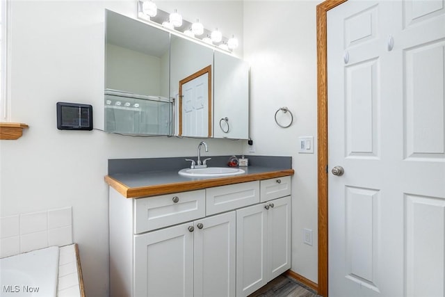 bathroom with vanity and a shower with shower door