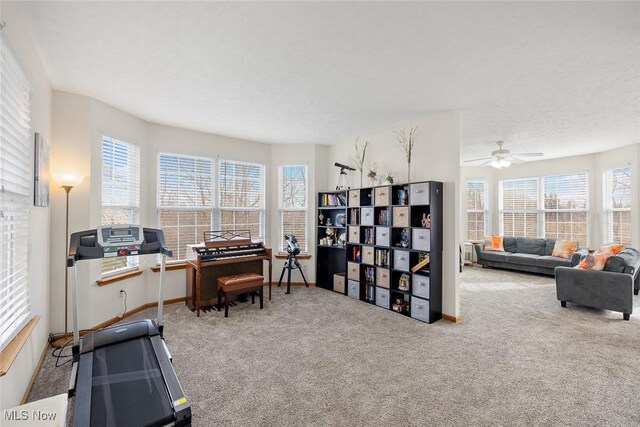 carpeted office space featuring a textured ceiling and ceiling fan