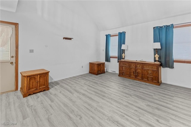 unfurnished living room with vaulted ceiling and light wood-type flooring