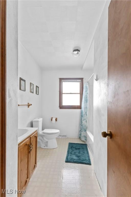 full bathroom with vanity, shower / tub combo, and toilet